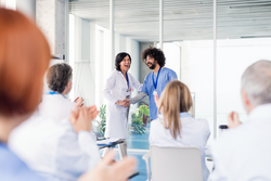 Group of doctors on medical conference, shaking hands.